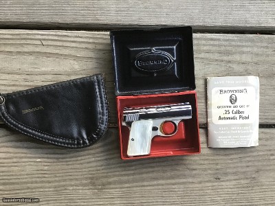 BROWNING BABY 25 AUTO, BRIGHT NICKEL, GOLD TRIGGER, PEARLITE GRIPS, IN THE BOX WITH OWNERS MANUAL & BROWNING ZIPPER POUCH ALL NEW COND.