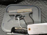 GLOCK 43 WITH BURNT BRONZE AMERICAN FLAG CERACOATED SLIDE, IN 9MM, IN EXCELLENT CONDITION - 1 of 13