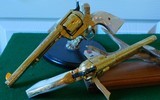 Pair of Colt 1st Gen. Single Actions Gold Finished Engraved Mother of Pearl Grips in 45 Cal. - 1 of 15