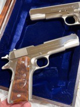 Cased pair of Colt 1911 Nickel pistols with presentation case.
.45 acp - 14 of 15