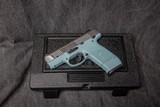 RUGER SR9c 9MM. TURQUOISE POLYMER FRAME & BRUSHED STAINLESS SLIDE