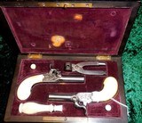 CASED PAIR OF MAGNIFICENT BELGIAN MUFF PISTOLS
36 CAL IVORY STOCKED
WITH ACESSORIES. VG COND - 1 of 5