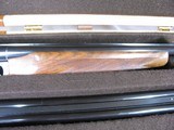 7997
SKB 385 Ducks Unlimited set, Only 200 were Made, 20/28 Ga, The stock is C-grade American walnut in high gloss finish with a semi-beavertail fore - 16 of 20