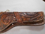 8884
Hand tooled leather holster, 38-40 “ waist, Lined with suede, will take a 10” Barrel. Darker brown leather. - 3 of 9