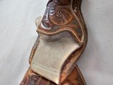 8884
Hand tooled leather holster, 38-40 “ waist, Lined with suede, will take a 10” Barrel. Darker brown leather. - 4 of 9